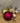 Rode kerstbal met hertenornament tussen kerstdecoratie; alleen rood verkrijgbaar